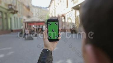 在乌克兰利沃夫用相机手机拍照。 年轻的休闲男子在外面用相机手机拍照。